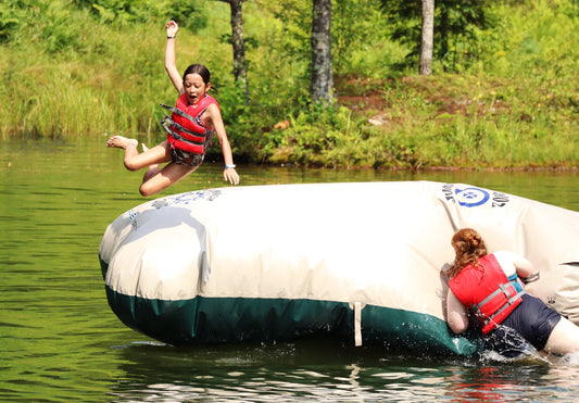 A kid jumping off a floaty at summer camp