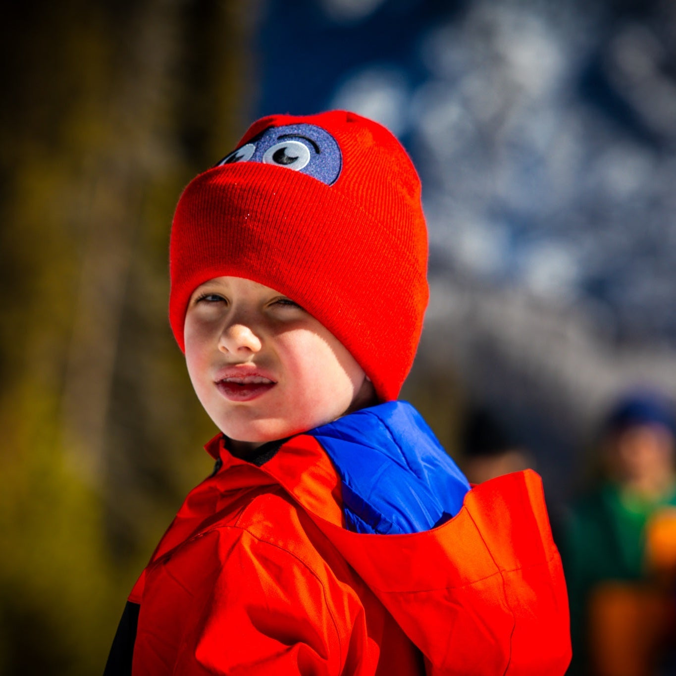 Kid wearing Hootie Hoo Owlet Beanie in True Red — action shot